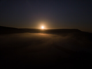 Low sun over mountains and clouds
