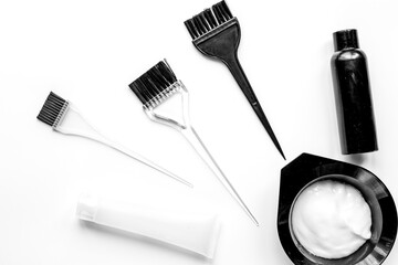 hair dye with brush on white table background top view