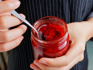 Red and yellow jam on plank wood and slice bread.