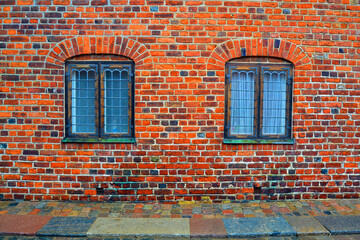 Old facade of the brick building with bars on the windows. Frederiksborg castle complex, Hillerod, Denmark
