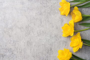 Concept of Mother's day holiday greeting with yellow tulip bouquet on gray background