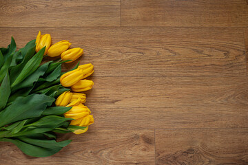 A bunch of Yellow tulips on the floor wooden background
