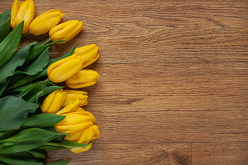 A bunch of Yellow tulips on the floor wooden background