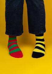 Legs with different stripes socks on background with copy space. World Down syndrome day background. Down syndrome awareness concept.