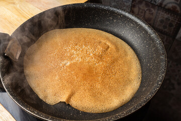 Frying cooking pancake on a frying pan. Home cooking
