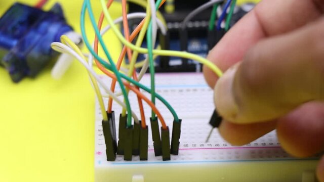 Connecting jumper wires to breadboard which shows electronic projects DIY concept. electronic projects concept