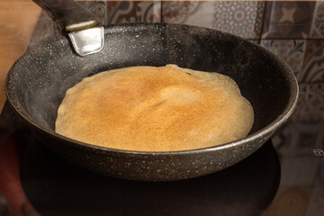 Frying cooking pancake on a frying pan. Home cooking