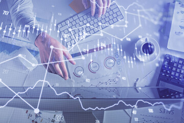 Multi exposure of man's hands typing over computer keyboard and forex graph hologram drawing. Top view. Financial markets concept.