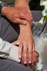 Close up of bride and groom holding hands. High quality photo