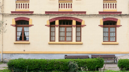 Ventana roja en fachada amarilla de edificio antiguo