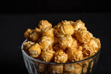 Popcorn in a glass plate on a dark background