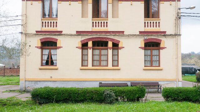 Ventana roja en fachada amarilla de edificio antiguo