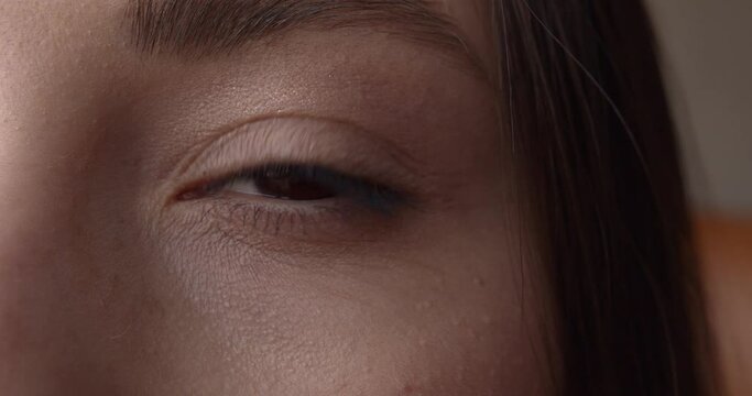 Close up of young woman with beautiful brown eye, thin lashes and perfect eyebrow. Details of female face. Natural beauty concept.