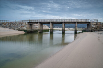 Bridge over the river in dune area of Baldaio beach at Carballo, Galicia, Spain