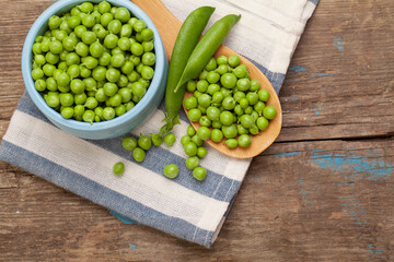 Green peas and pods on wooden background