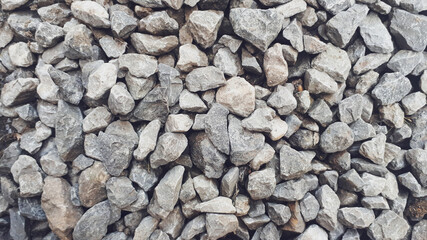 Gravel texture. Pebble stone background. Light grey closeup small rocks. Top