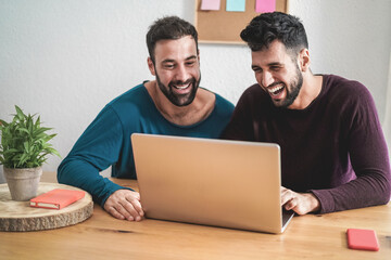 Gay couple having video call at home using laptop computer during lockdown isolation - Focus on right face