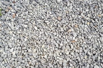 Gravel texture. Pebble stone background. Light grey closeup small rocks. Top