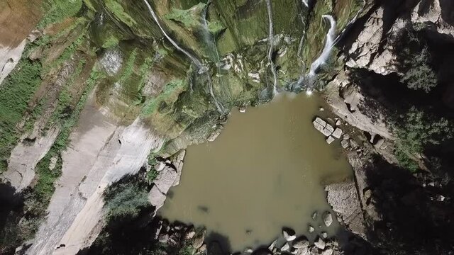 Aerial Top Ascend: Waterfall From Rocks In Forest On Sunny Day