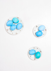 Colored eggs on plate with on white background. Flat lay. Copy space.  Easter concept. Top view.