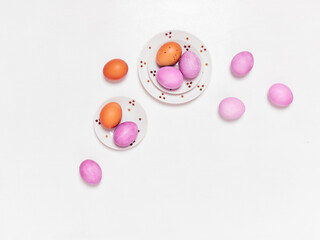 Colored eggs on plate with on white background. Flat lay. Copy space.  Easter concept. Top view.