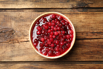 Fresh cranberry sauce on wooden table, top view