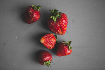 fresh farm strawberries lie on a gray table
