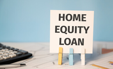HOME EQUITY LOAN on a sticker beside a calculator and a pen. Finances and business concept.