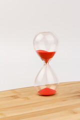 Crystal hourglass on wooden background as a concept of passing time for business term, urgency and...
