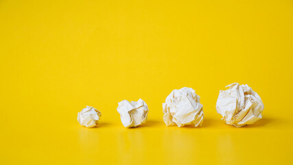 various size of crumpled paper balls on grunge yellow background ,panorama and copy space