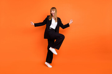 Full size photo of young happy smiling good mood crazy girl dancing enjoying weekend isolated on orange color background