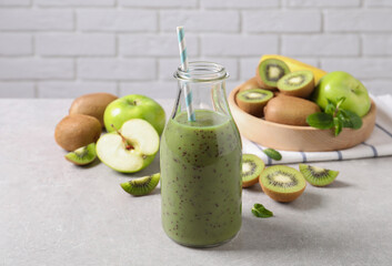 Delicious kiwi smoothie and fresh fruits on light table