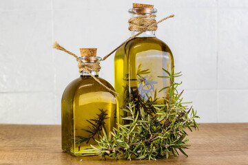 Essential rosemary oil in a glass bottles with a rosemary branches