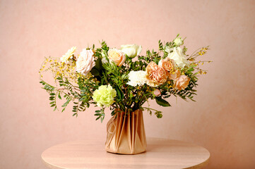 Beautiful flowers in vase on a table with beige background. Women's, mother's day, love concept. Spring, summer season.