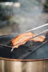 Grilling barbecue on fire smoked at backyard on day