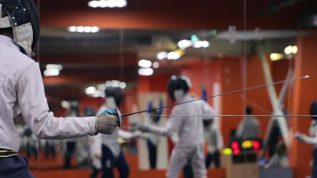 Teenagers practicing fencing at a fencing school 