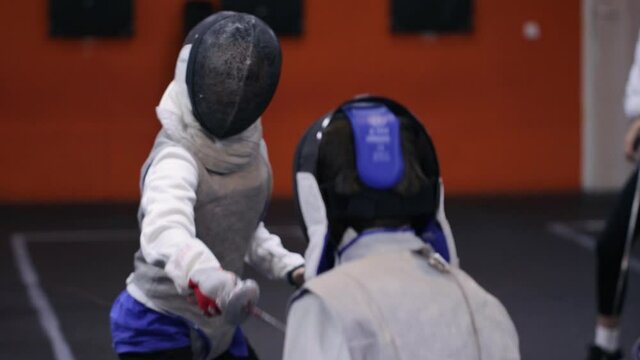 Teenagers practicing fencing at a fencing school 