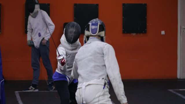 Teenagers practicing fencing at a fencing school 