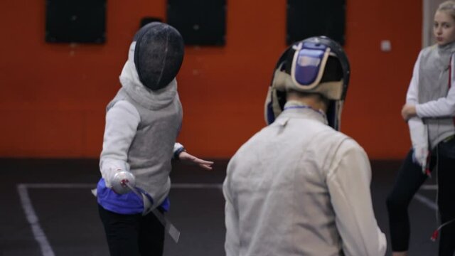 Teenagers practicing fencing at a fencing school 