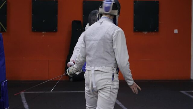 Teenagers practicing fencing at a fencing school 
