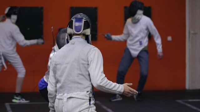 Teenagers practicing fencing at a fencing school 