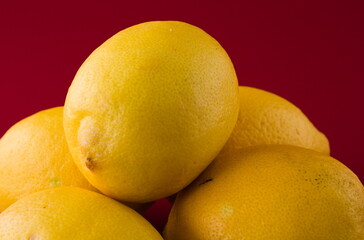 Group of lemons close up, isolated on red background