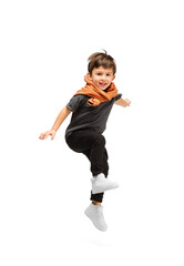 Jumping, running. Happy, smiley little caucasian boy isolated on white studio background with...