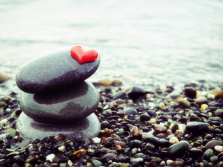 Stacked Zen stones with heart on sea background - Concept of love and balance