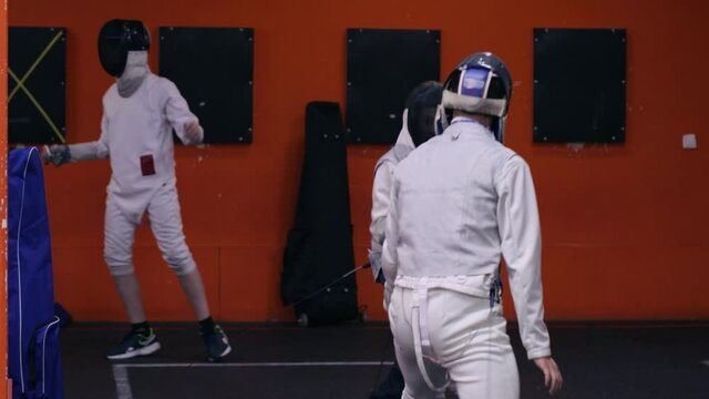 Teenagers practicing fencing at a fencing school 