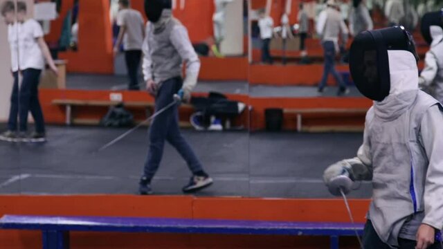 Teenagers practicing fencing at a fencing school 