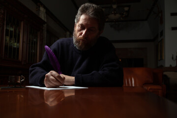 Man writes letter with pen in old castle