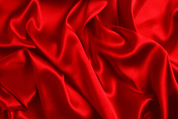 Red silk or satin luxury fabric texture can use as abstract background. Top view.