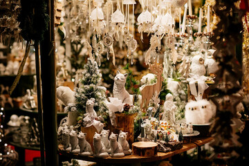 Fototapeta premium Handcrafted colorful toy at traditional advent market, Close up, Selective focus, Christmas holiday decoration for tree with white cats for sale in the center of Salzburg, Austria