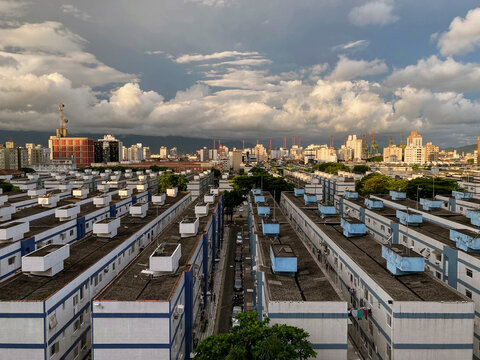 Perspective aerial view of the neighborhood of Aparecida from the housing project to the port of Santos on a sunny afternoon with clouds.